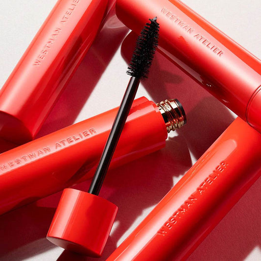 Westman Atelier Buildable Mascara in vibrant red packaging with a black wand for voluminous lashes