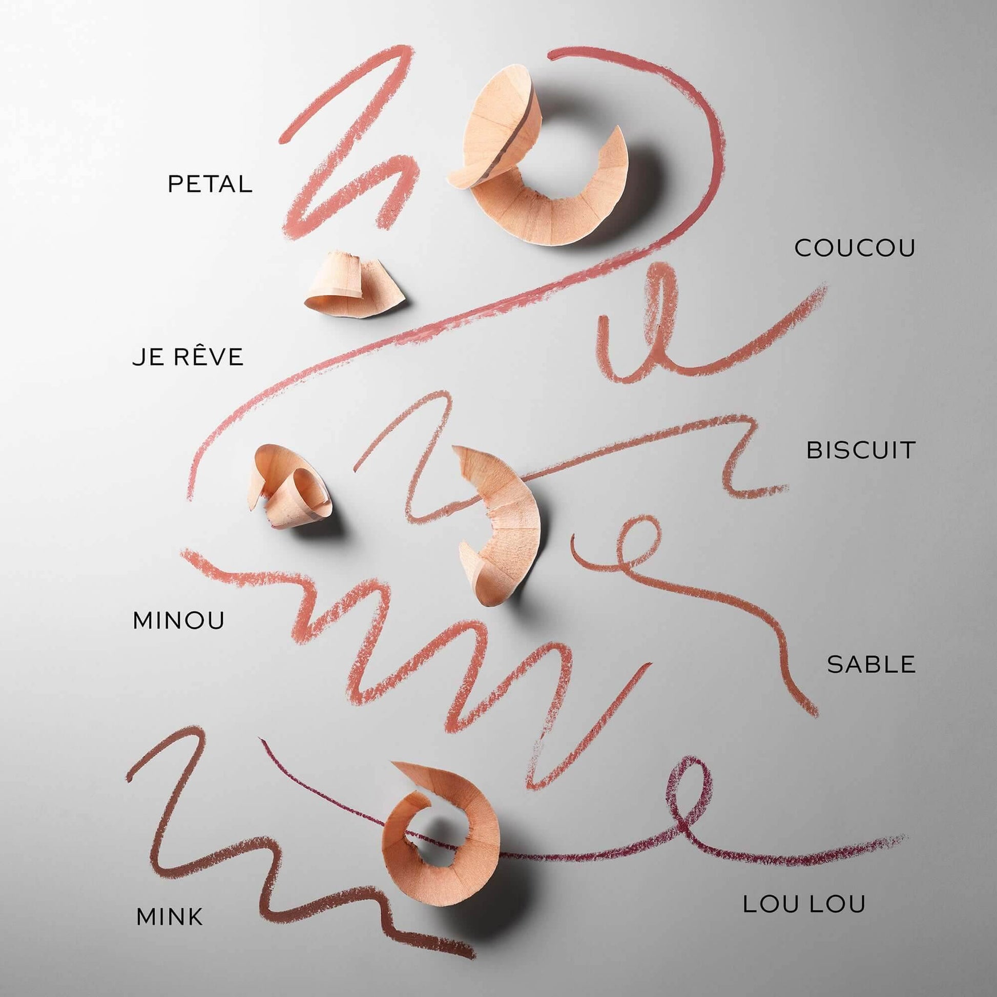 Westman Atelier Lip Shape Lip Liner shades displayed with wood shavings on a grey background