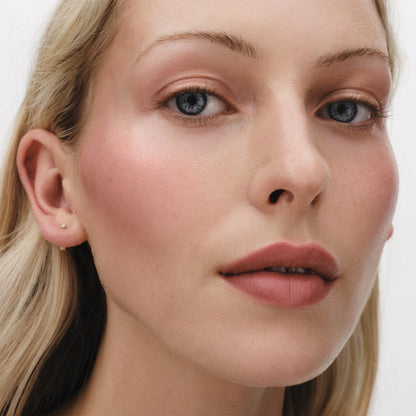 Close-up of a model wearing Westman Atelier Petite Petal Edition makeup showcasing natural beauty with soft blush and lip color